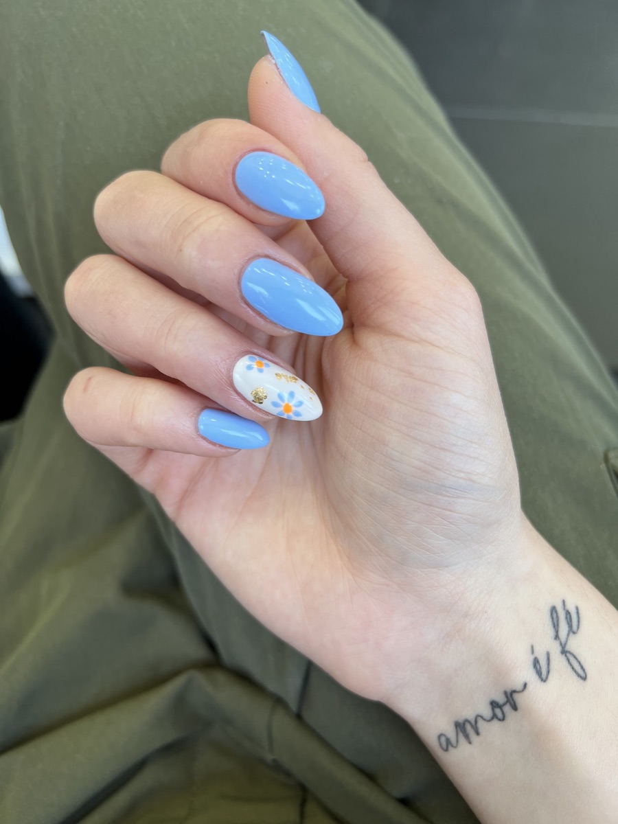 Baby-blue gel nails with a hand-painted daisy accent nail