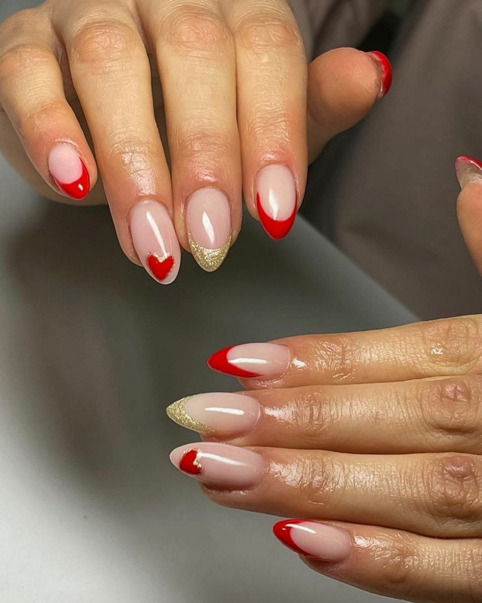 Red French tip nails with heart and gold glitter accents